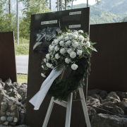 Gedenkfeier am Ort des ehemaligen KZ-Außenlagers Dipoldsau Kranz mit weißen Blumen am Ort des ehemaligen KZ-Außenlagers Dipoldsau