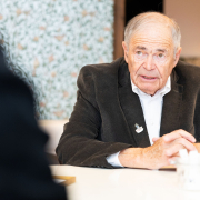 "Mauthausen-Baby" Mark Olsky beim Pressegespräch © MKÖ/Alissar Najjar Mark Olsky, mit grauen Haaren im dunklen Sakko, sitzt an einem Tisch und beantwortet Fragen der Presse.