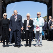v.l.n.r.: Die drei Mauthausen-Babys Hana Berger Moran, Mark Olsky und Eva Clarke sowie Zeitzeugin Katja Sturm-Schnabl © MKÖ/Alissar Najjar Hana Berger Moran, Mark Olsky, Eva Clarke sowie Katja Sturm-Schnabl gehen Hand in Hand durch das Tor des ehemaligen Konzentrationslagers Mauthausen.