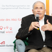 "Mauthausen-Baby" Mark Olsky bei der Buchpräsentation © MKÖ/Alissar Najjar Mark Olsky, mit grauen Haaren im dunklen Sakko, sitzt auf einem Ledersessel und beantwortet Fragen der anwesenden Teilnehmer:innen.